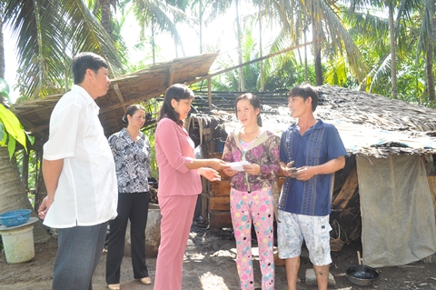 Đồng chí Hồ Thị Hoàng Yến - Phó Bí thư Thường trực Thành uỷ (ở giữa) chia xẻ rui ro và trao tiền hỗ trợ cho gia đình (Ảnh: ĐB)
