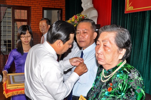 Đồng chí Bùi Minh Tuấn - Phó Bí thư Thành uỷ trao huy hiệu đảng cho đảng viên. (Ảnh: ĐB)